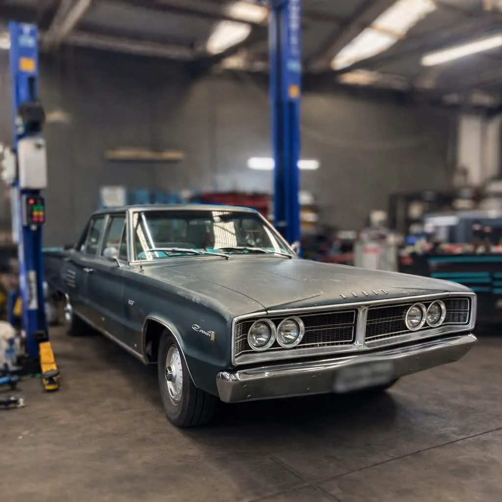 A classic Chrysler raised on the two post hoist in the workshop
