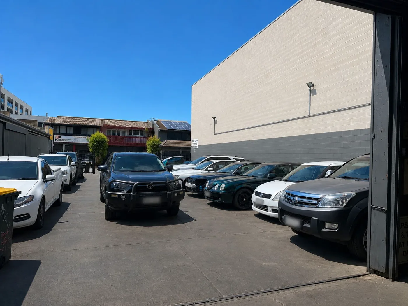Customer cars lined up outside the workshop on Byron Place
