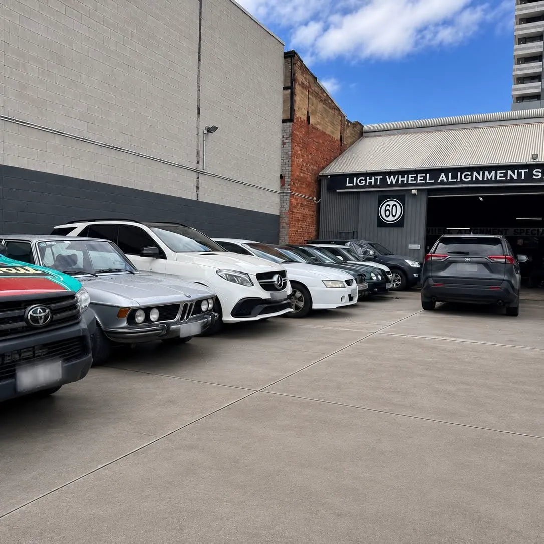 Customer cars parked along the length of the workshop building