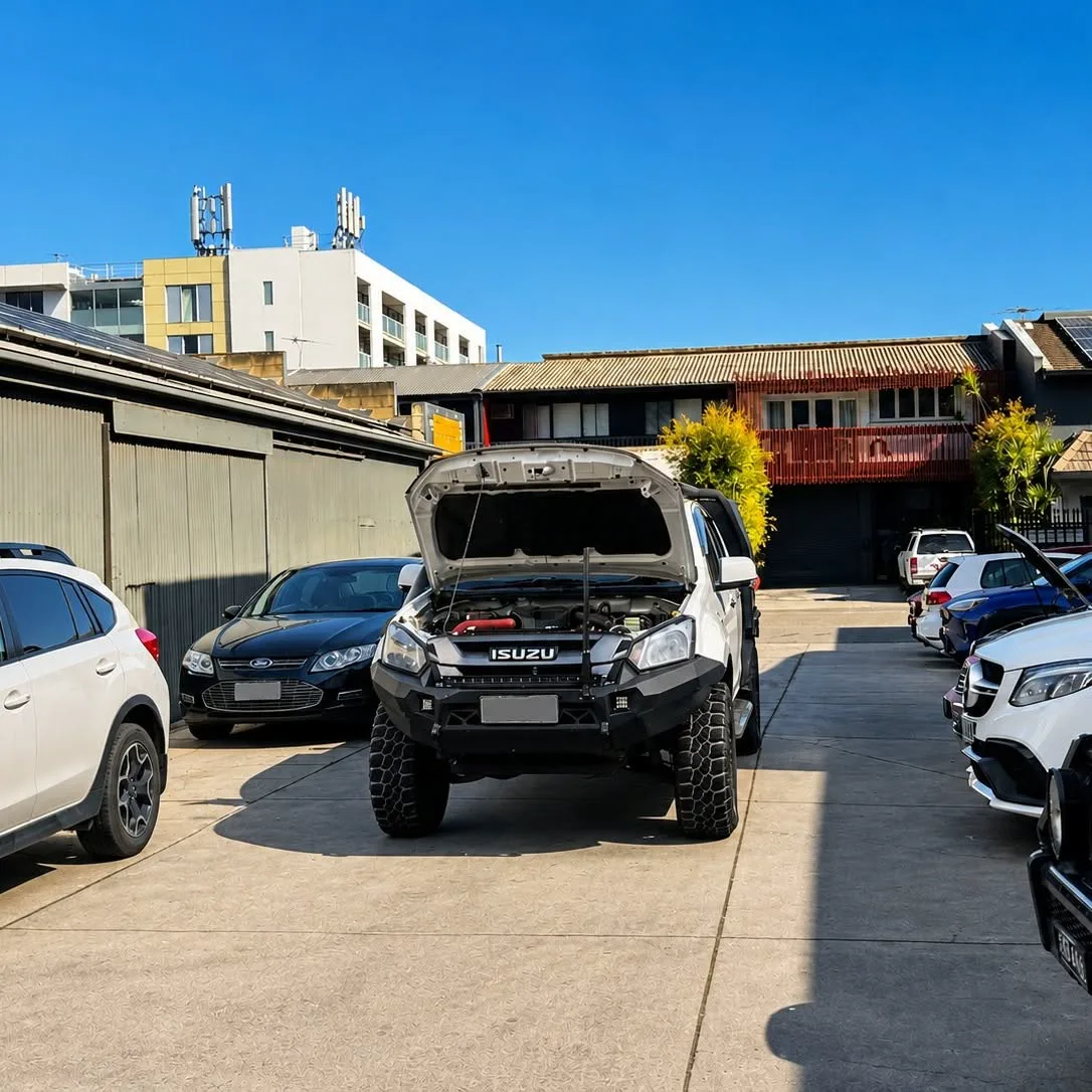 Four wheel drives and customer cars in the yard outside the workshop