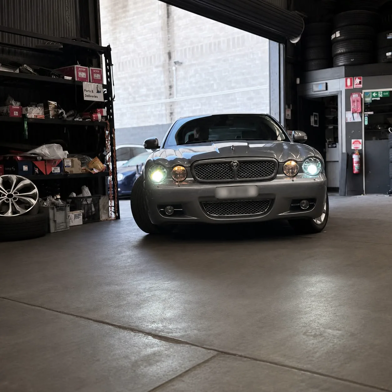 A Jaguar XJ inside the workshop roller door