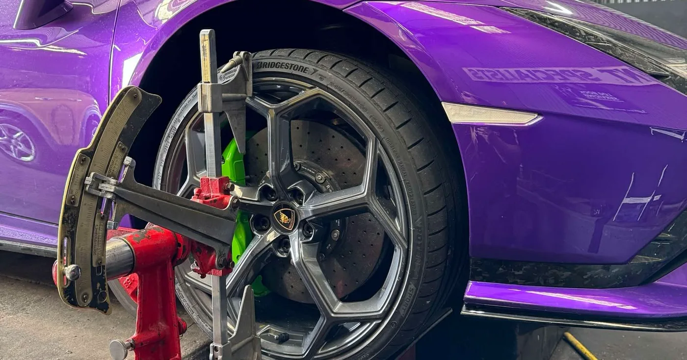 An alignment clamp fitted to the front wheel of a Lamborghini Huracan on the rack at the Adelaide workshop